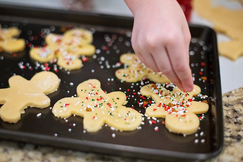 Assorted holiday cookies and baked goods on a festive tray with seasonal decorations
