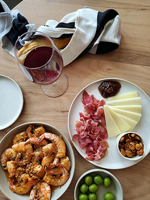 Assorted Spanish tapas and wine glasses on a rustic wooden table